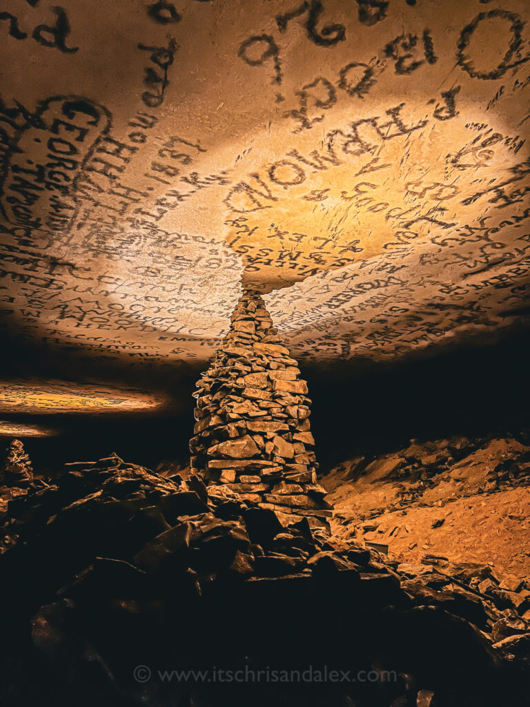 a limestone tower in the Gothic Avenue of Mammoth Cave National Park. Signatures written in soot are covering the ceiling.