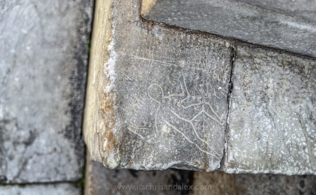 a carving into marble at the Baptistery in Pisa, Italy