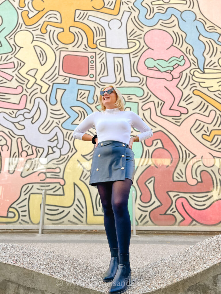 Chris stands in front of the Keith Haring mural, Tuttomondo in Pisa, Italy