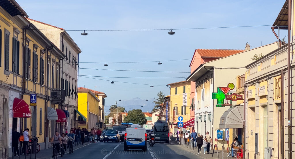 A street in Pisa, Italy with the mountains visible at the end